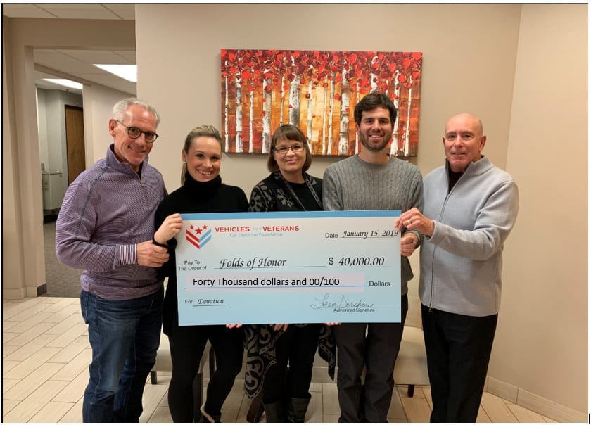 Folds of honor receiving giant check from Vehicles for Veterans car donation charity.