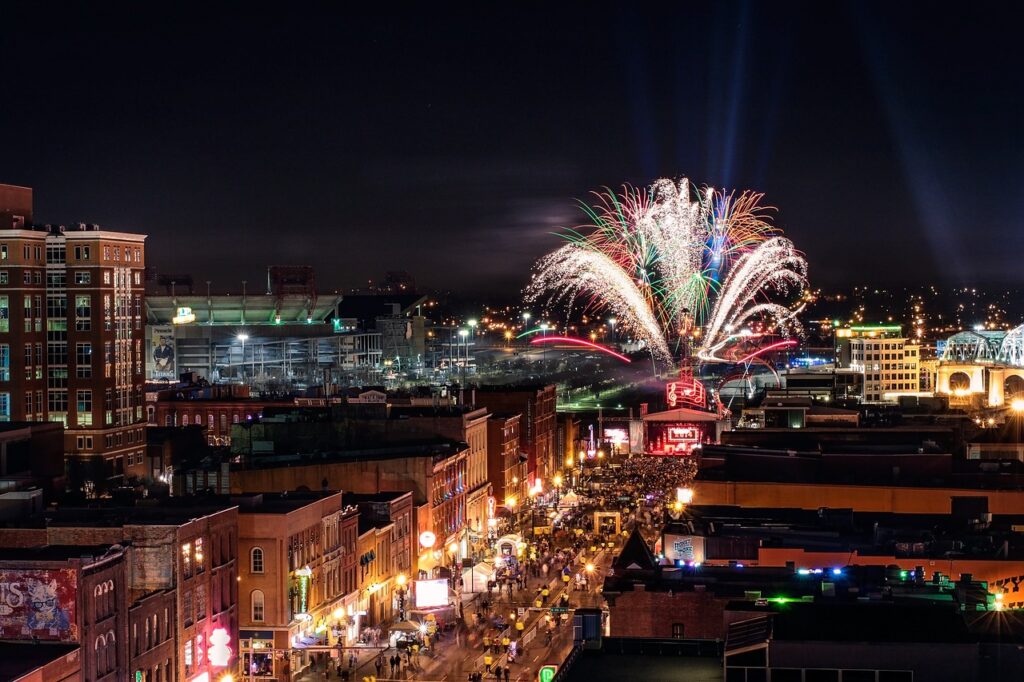 nighttime downtown view of Nashville, TN with fireworks display in background