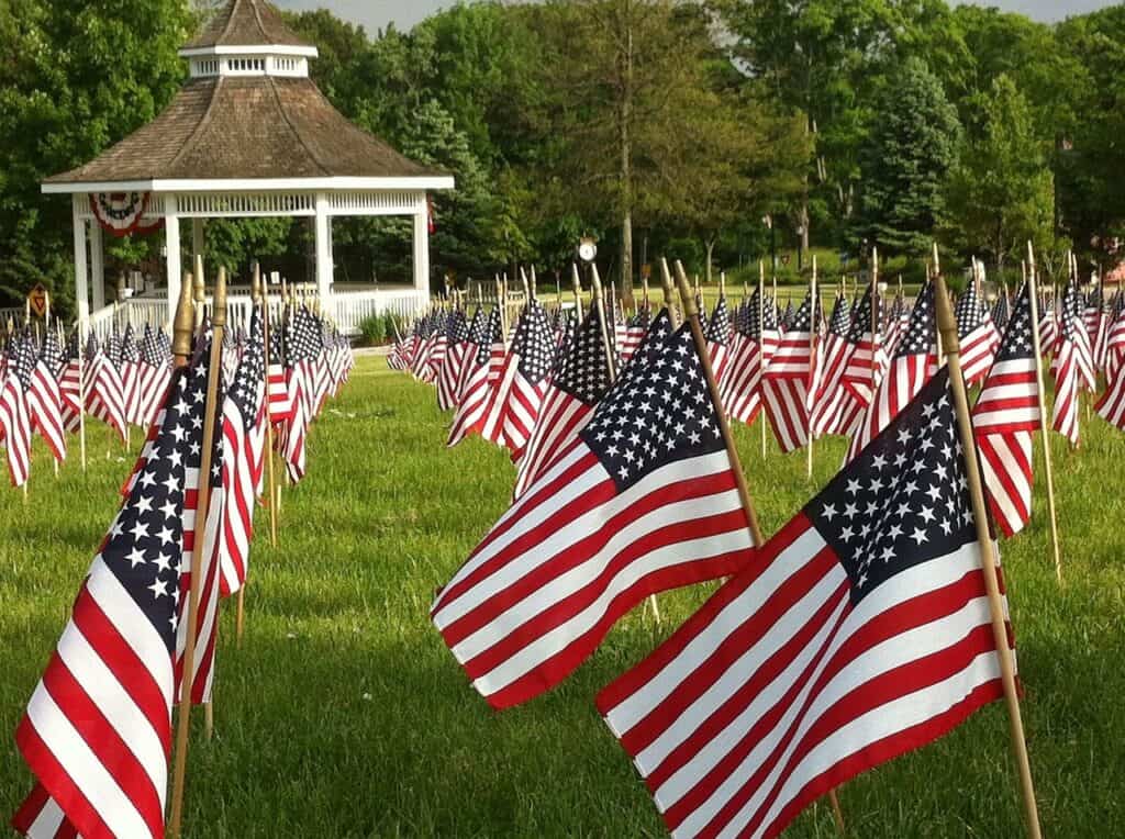 American flags in a field in front of a gazebo